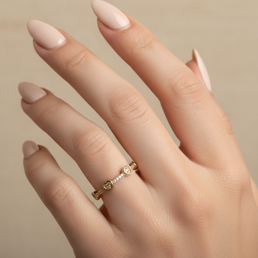 Anillo con corazones y diamantes en mano