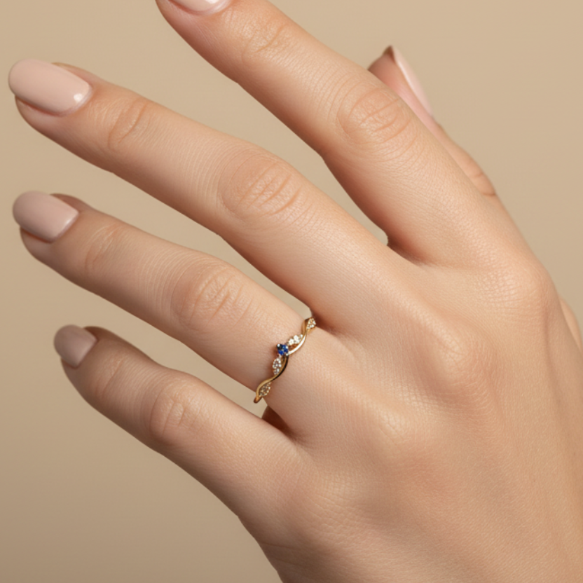 Anillo con corona y piedra azul en mano