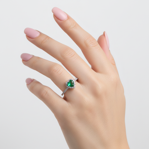 Anillo corazón verde mirando hacia arriba en la mano