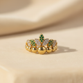 Anillo corona esmeraldas fondo cálido sin bolas de luz