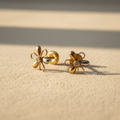 Aretes de flor con circonita fondo beige profesional