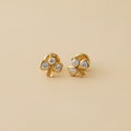 Aretes de trébol todas piedras blancas fondo beige