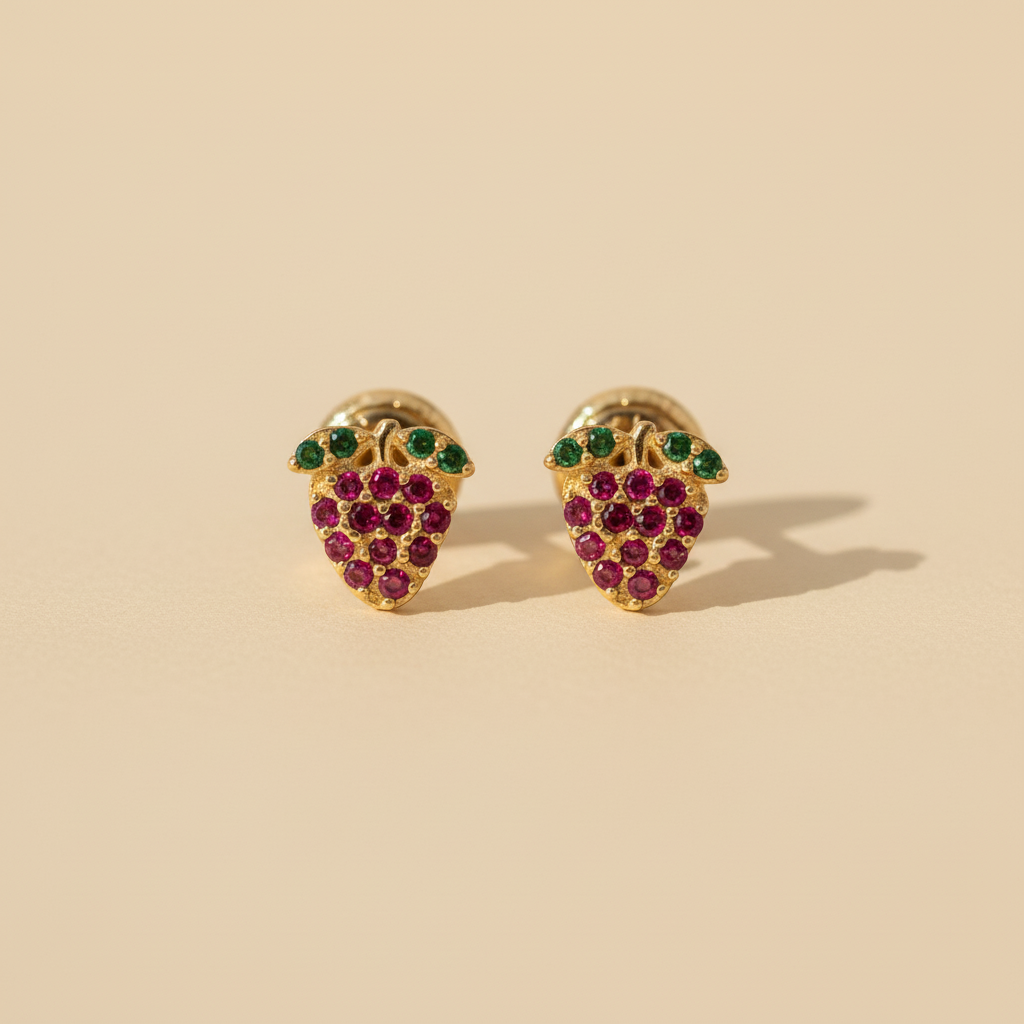 Aretes fresa oro 18k ambos de frente fondo beige luz natural