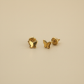Aretes mariposa pequeños oro 18k fondo beige profesional