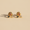 Aretes pez oro 18k topos originales de frente fondo beige