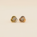 Aretes rosa tricolor fondo beige plano minimalista