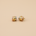 Aretes tricolor oro elegante fondo beige limpio