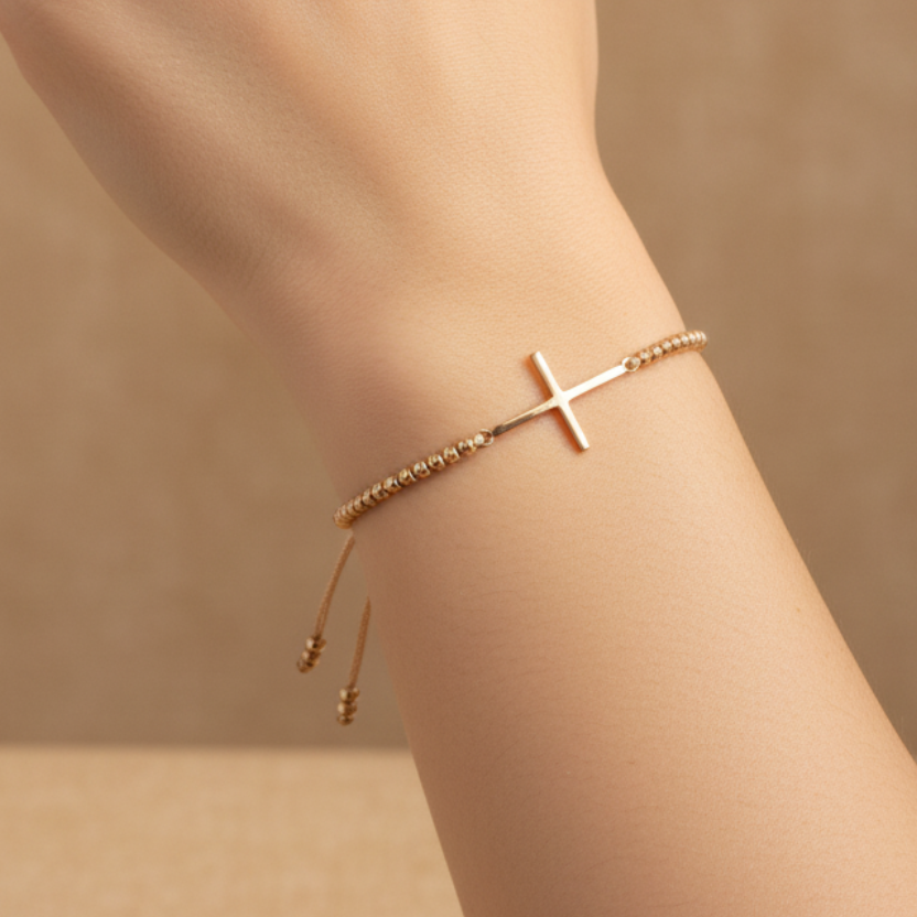 Pulsera balines oro en mano con fondo beige elegante