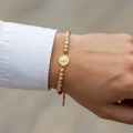 Pulsera tejida arcángel en mano de hombre