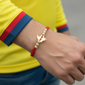 Pulsera tejida la nuestra en mano de hombre con camiseta de Colombia