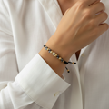 Pulsera tejida piedras en mano