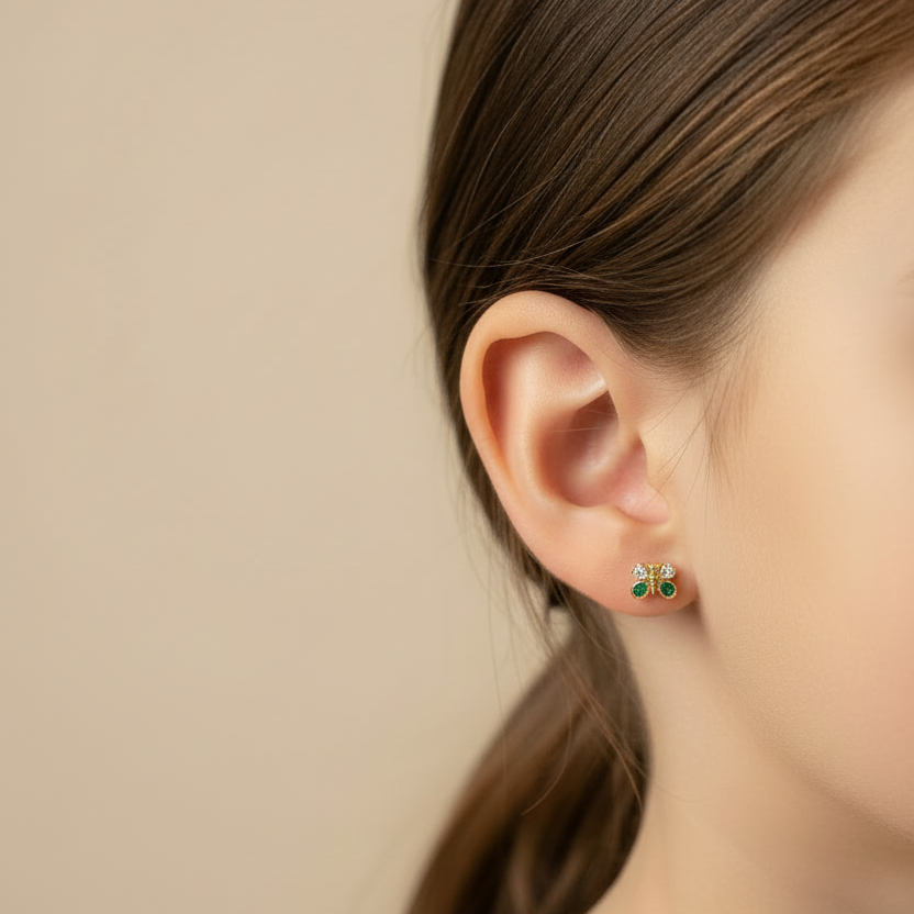 Topitos mariposa en oro al revés en oreja de niña
