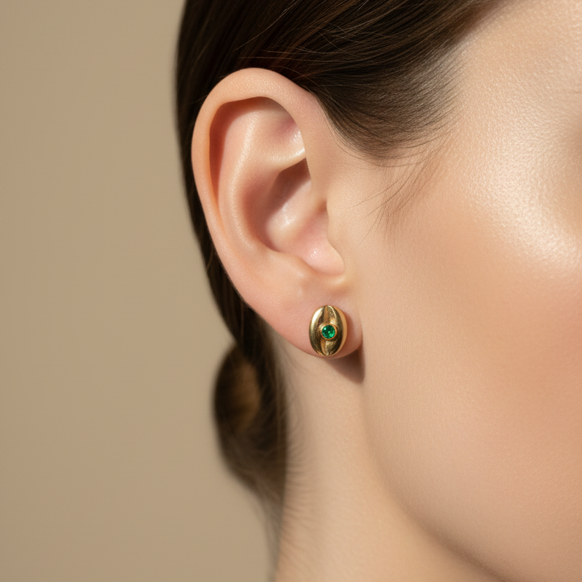 Topitos ovalados con esmeralda 0.1cm muy pequeños en oreja de mujer